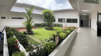Patio ajardinado y corredor de consulta externa.